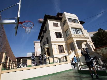 Un alumno practica baloncesto en un colegio.