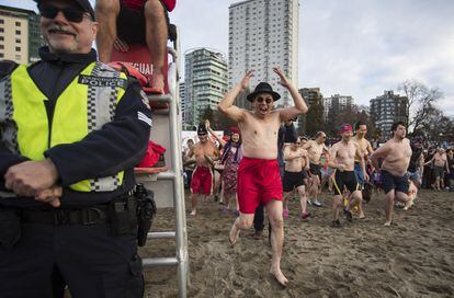Un policía cubre el puesto de un socorrista durante la celebración de la 100 edición de la 'Polar Bear Swim', celebrada en Vancuver (Canadá).