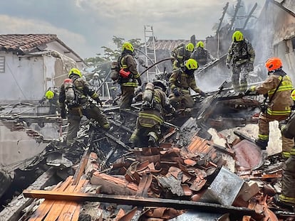 Bomberos trabajan en la casa donde se estrelló la avioneta en Medellín, Colombia.