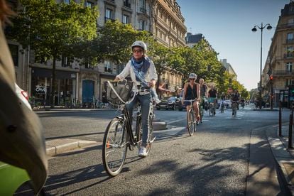 Varias personas pedalean por un carril bici de París.