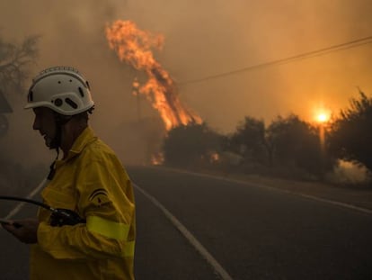 Un bombero pasa por una carretera durante un incendio en Granada, España.