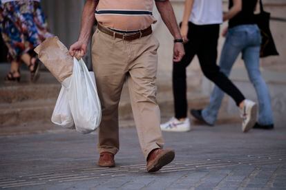 Un hombre carga con las bolsas de la compra, este martes en Valencia.