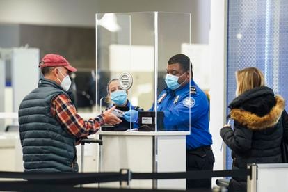 A Transportation Security Administration agent attends a traveler at a checkpoint in a terminal at LaGuardia Airport, New York.