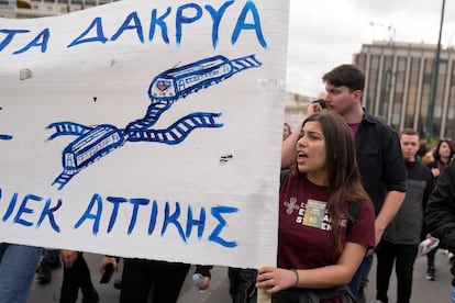 Estudiantes sujetan un cartel que denuncia la tragedia ferroviaria de Tempe, en la que murieron 57 personas al chocar dos trenes en esa localidad del este de Grecia, este jueves en Atenas.