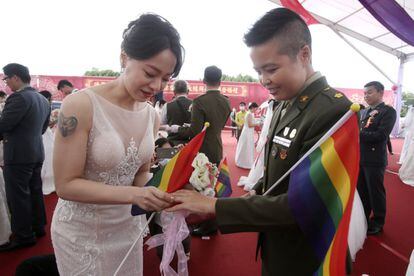 Meng Yumi coloca este viernes un anillo en el dedo de su novia, Wang Yi, durante la ceremonia anual de boda múltiple que organiza el ejército taiwanés.
