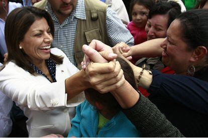 Laura Chinchilla saluda a partidarios en la basílica de la Virgen de los Ángeles, en Cartago, adonde acudió ayer para dar gracias por la victoria.