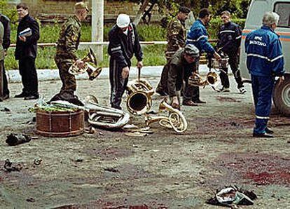 La policía retira instrumentos de una banda militar en Kaspíik, tras el atentado.