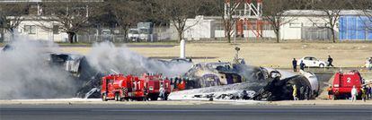 Los bomberos apagan el fuego de un avión de carga de mercancías en el aeropuerto de Narita (Tokio).