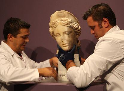 Dos operarios colocaban ayer la escultura de la diosa en el Museo Municipal de Santiponce Fernando Marmolejo.