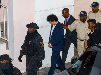 Samuel Bankman-Fried, al salir esposado y escoltado por la policía de la vista en el juzgado de Nassau que le denegó la libertad condicional.