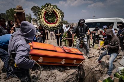 Familiares de Lorenzo Islas bajan el ataúd en el panteón municipal de Valle de Chalco, Estado de México.