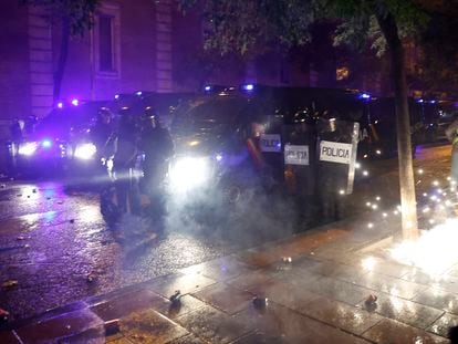 Los manifestantes lanzan material pirotécnico contra la policía en la calle Ferraz de Madrid, junto a la sede del PSOE.