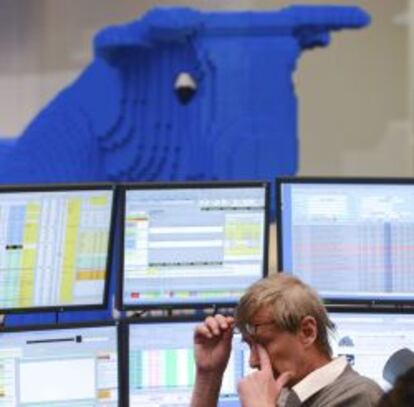 Un bróker gesticula frente a numerosos monitores en el parqué de la bolsa de Fráncfort (Alemania).