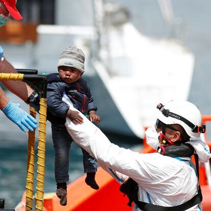 Un niño rescatado de una patera en el Mediterráneo por agentes de salvamento marítimo es bajado a tierra firme en el puerto de Arguineguín, Gran Canaria, el 31 de marzo de 2020.