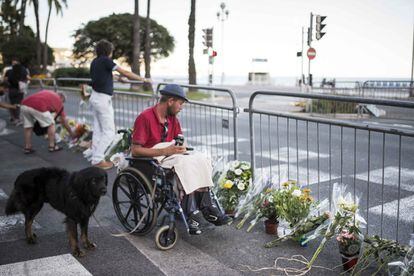 Ciudadanos y turistas se acercan a las vallas donde se están colocando flores en recuerdo a los fallecidos en el ataque terrorista, el 16 de julio de 2016.
