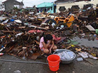 na joven hace la colada entre escombros en una zona devastada de Leyte.
