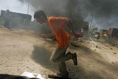 Un colono pasa junto a una hoguera en el asentamiento de Nevé Dekalim, donde se ha bloqueado la entrada a los soldados israelíes.