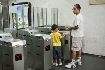 Un nen valida la seva T-12 al metro de Barcelona.