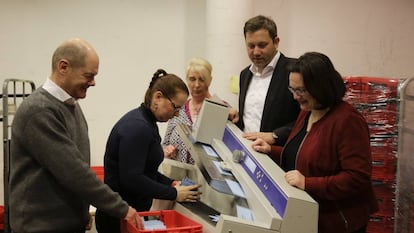 El líder del SPD y alcalde de Hamburgo, Olaf Scholz (izq.), y la líder del partido en el Bundestag, Andrea Nahles (dch.),  durante el recuento de votos en el referéndum sobre la gran coalición celebrado entre las bases. (AP Photo/Markus Schreiber)