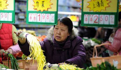 Una consumidora selecciona algunas verduras en un supermercado de Hefei, en el este de China.