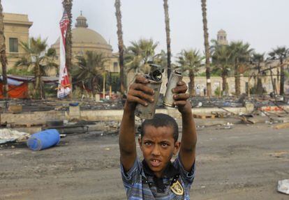 Un niño muestra al fotógrafo los botes vacíos del gas lacrimógeno usados el miércoles 14 de agosto por la policía para desalojar los campamentos de los seguidores del presidente depuesto Morsi.