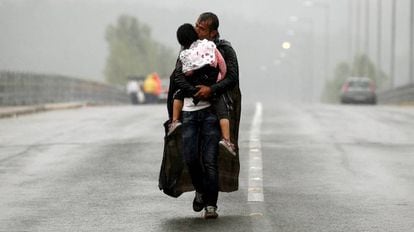Un refugiado sirio besa a su hija mientras se acerca a la frontera entre Grecia y Macedonia en septiembre de 2015.