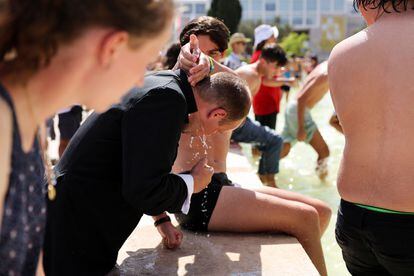 A pilgrim pours water for a priest at a fountain near the Jerónimos Monastery as they await the Pope, this Wednesday.