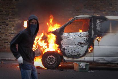 Un joven participa en los disturbios acaecidos el lunes en el barrio de Hackney, en Londres.