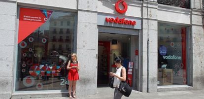 Una joven pasa por delante de una tienda Vodafone en Madrid.