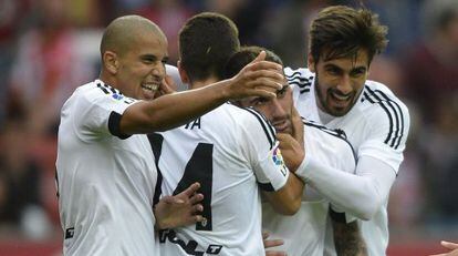 Los compa&ntilde;eros del Valencia celebran el gol con Alc&aacute;cer.