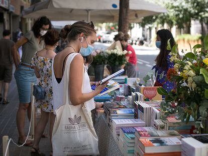 Una compradora, ante uno de los pocos puestos callejeros en el Sant Jordi de este jueves en Barcelona.