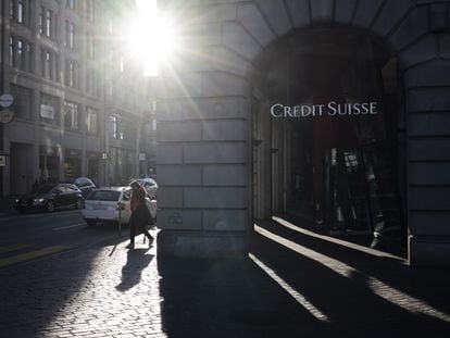 Una mujer caminaba junto a un logo de Credit Suisse en Zúrich el lunes, un día después de ser absorbido por UBS.