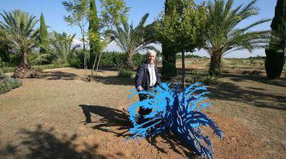 El artista, con una de sus esculturas en el jardín de su casa.