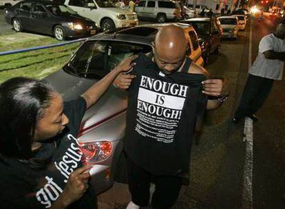 Dos manifestantes llegados ayer a Jena preparan una camiseta en la que se lee "¡Basta ya!".