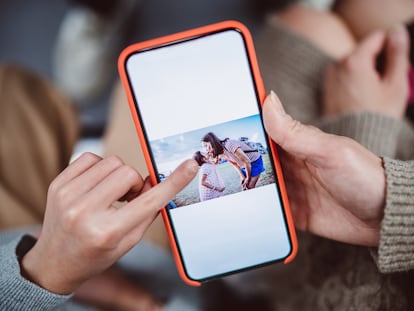 Un teléfono muestra la imagen de una madre con su hija.