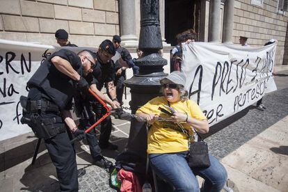 Mossos rompen la cadena que ata a una mujer frente a la Generalitat este viernes.
