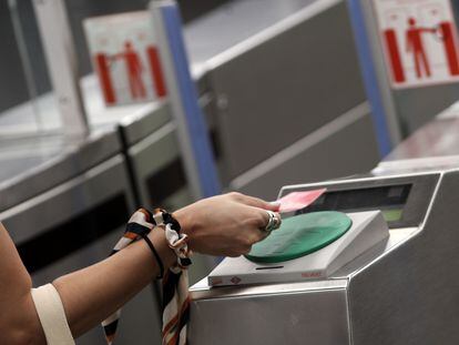 Una mujer pasa su billete en el torno del Metro Plaza de España, en Madrid.