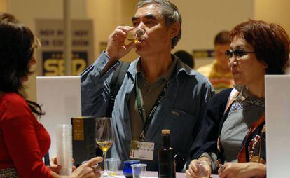 Una pareja cata un aceite en uno de los expositores de la feria Expoliva Jaén.
