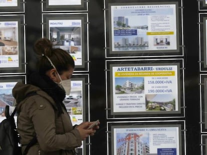 Una mujer pasa por delante de un portal inmobiliario de venta y alquiler en Bilbao.