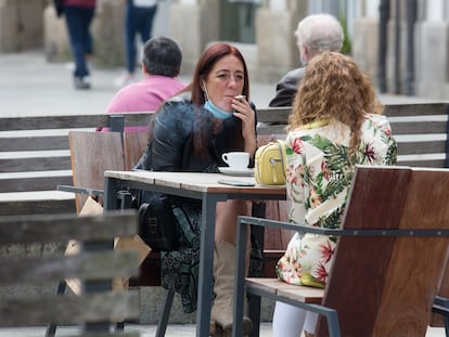 Una persona fuma en una terraza durante el primer día de la prohibición de realizarlo en la vía pública si no existe una distancia de dos metros de seguridad.