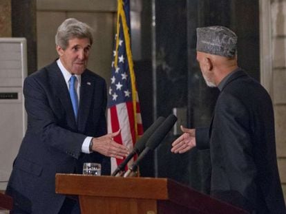 John Kerry (izquierda) y Hamid Karzai se estrechan la mano al final de su rueda de prensa en Kabul.