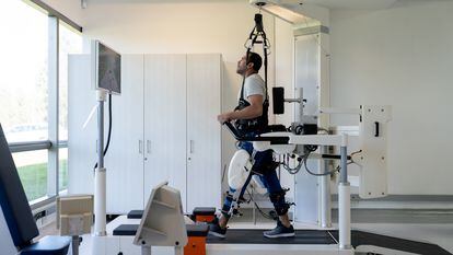 Patient in physical therapy doing exercises with an exoskeleton at the hospital - healthcare and medicine concepts. Design on screen was made from scratch by us