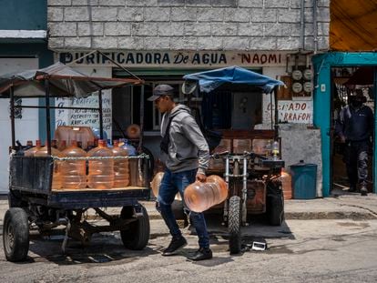 Un joven coloca garrafones de agua purificada en un remolque para repartirlos en Ecatepec (Estado de México), en 2021.