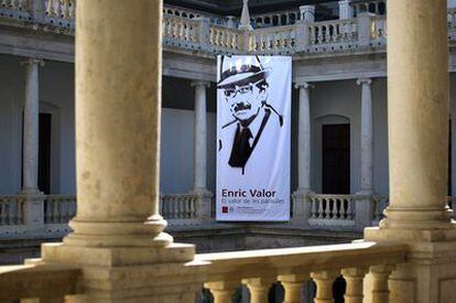 Una imagen de Enric Valor preside el claustro del edificio de La Nau, de la Universitat de València, que acoge la exposición sobre el escritor.