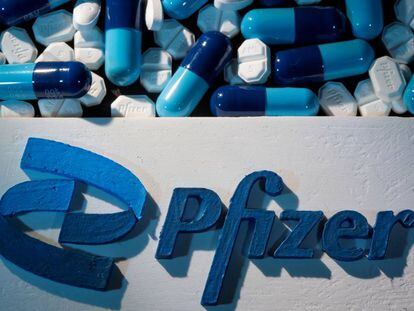 Logo de Pfizer impreso en 3d junto a píldoras fabricadas por el laboratorio