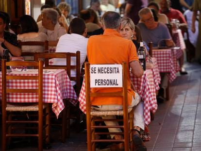 Cartel de "Se necesita personal" en la terraza de un restaurante en Tossa de Mar (Girona).