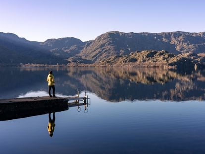 Una mujer disfruta del anochecer en el muelle del Lago de Sanabria en Zamora.