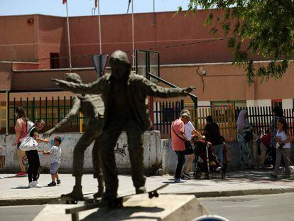 Un colegio en la Avenida Juan Carlos I de Parla, junto a la estatua de unos niños en monopatín.