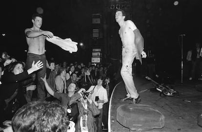 Joe Strummer intercambiándose la camiseta con alguien del público en un concierto de The Clash en 1977.