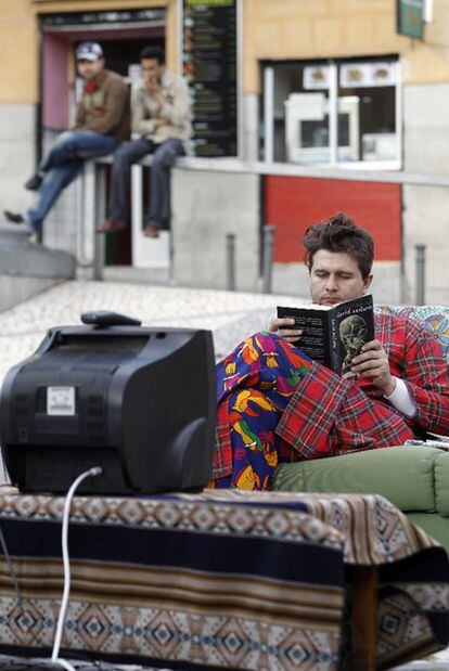 Un lector, en un sofá puesto en la plaza de Agustín Lara por la librería Traficantes de Sueños.